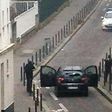 Hooded gunmen Cherif Kouachi and his brother Said Kouachi face police officers near the offices of the French satirical newspaper Charlie Hebdo in Paris, during the attack