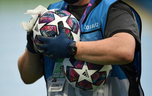 A member of the ground staff disinfects a ball before the Champions League last 16 match between Manchester City and Real Madrid at the Etihad Stadium in Manchester on August 7