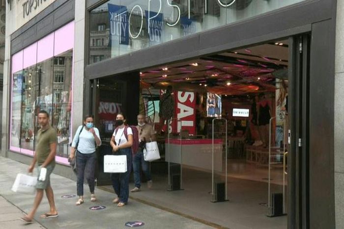People walk the busy streets of Oxford Street in central London as it becomes compulsory to wear masks in shops