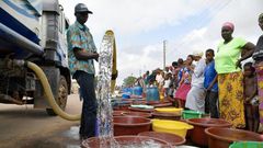 A supplier distributes water from a tanker truck to residents of Bouake at the start of July 2018