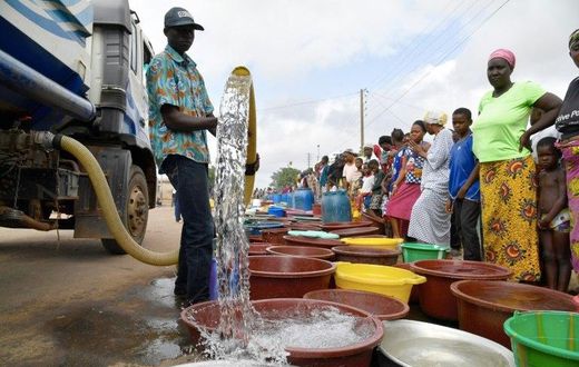 A supplier distributes water from a tanker truck to residents of Bouake at the start of July 2018