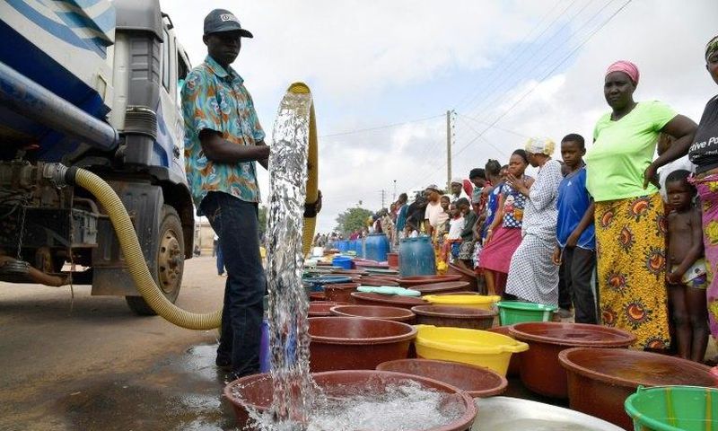 A supplier distributes water from a tanker truck to residents of Bouake at the start of July 2018