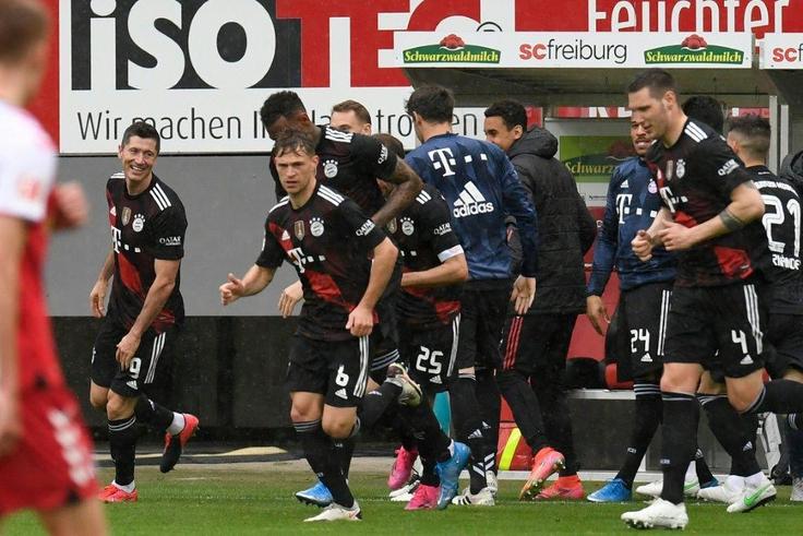 Bayern Munich striker Robert Lewandowski (L) celebrates scoring his 40th Bundesliga goal this season to equal Gerd Mueller's 49-year-old record