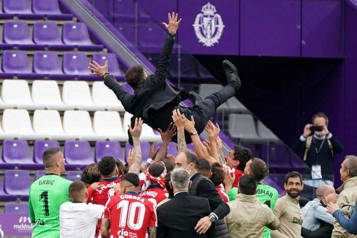 Flying high: Atletico Madrid players toss coach Diego Simeone to celebrate their Liga title