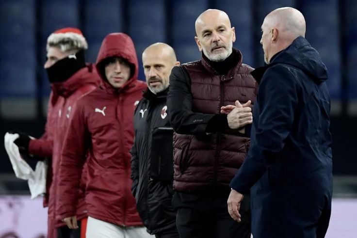 Genoa coach Rolando Maran (R) shakes hands with AC Milan's Stefano Pioli on December 16, 2020.