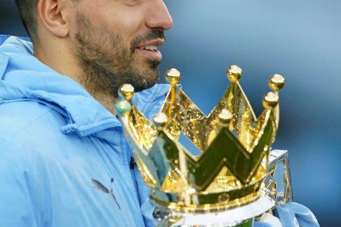 Manchester City striker Sergio Aguero cradles the Premier League trophy
