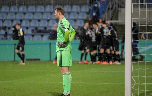 Bayern Munich goalkeeper Manuel Neuer (L) looks on as Kiel's players celebrate during Wednesday's shock German Cup defeat