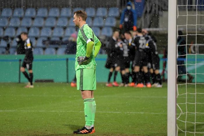 Bayern Munich goalkeeper Manuel Neuer (L) looks on as Kiel's players celebrate during Wednesday's shock German Cup defeat