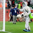 A cleaner disinfects the goalposts during the Club World Cup in Doha in February