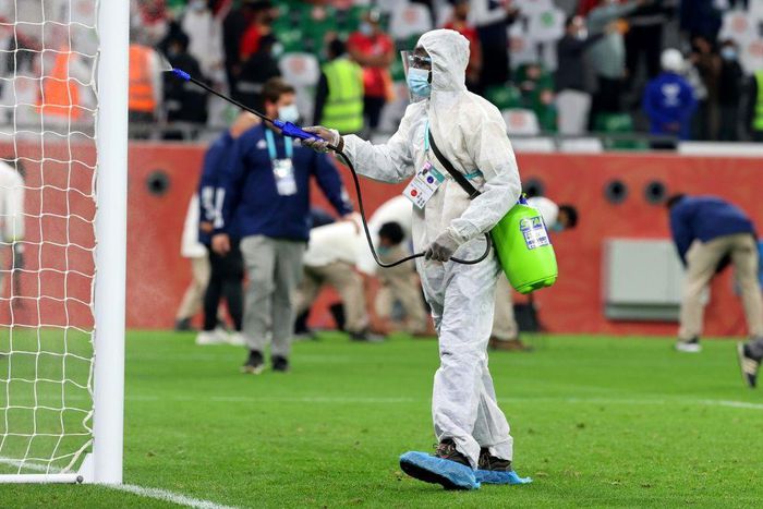 A cleaner disinfects the goalposts during the Club World Cup in Doha in February