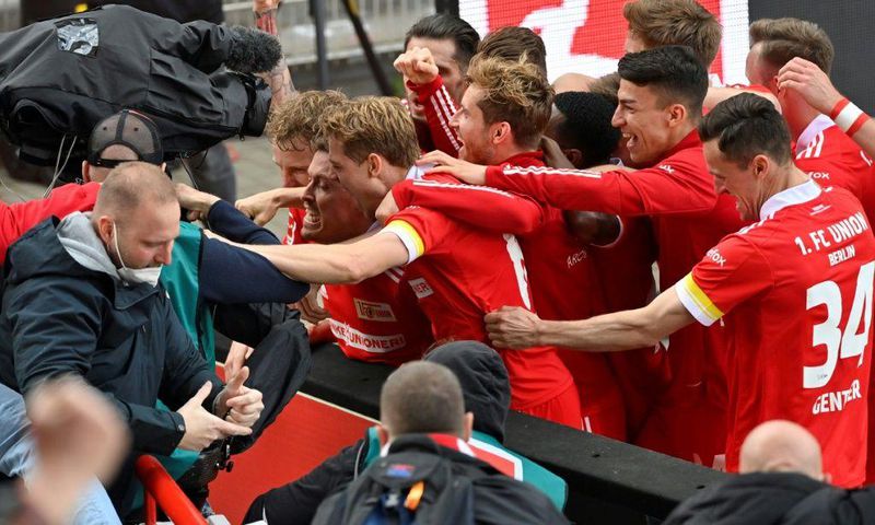 Union Berlin striker Max Kruse (C) is mobbed by team-mates after his winning goal