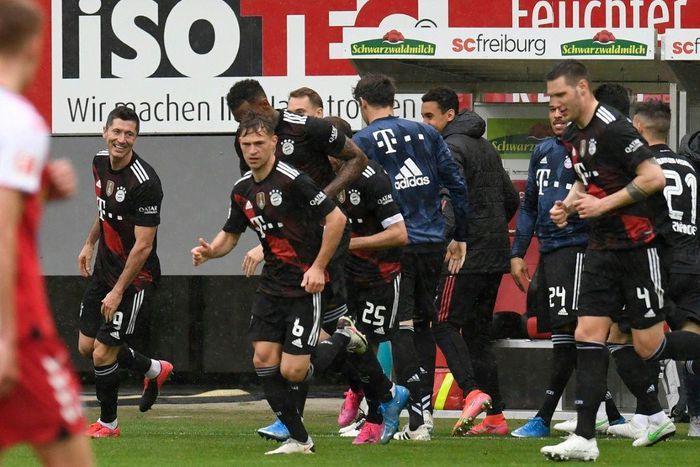 Bayern Munich striker Robert Lewandowski (L) celebrates scoring his 40th Bundesliga goal this season to equal Gerd Mueller's 49-year-old record