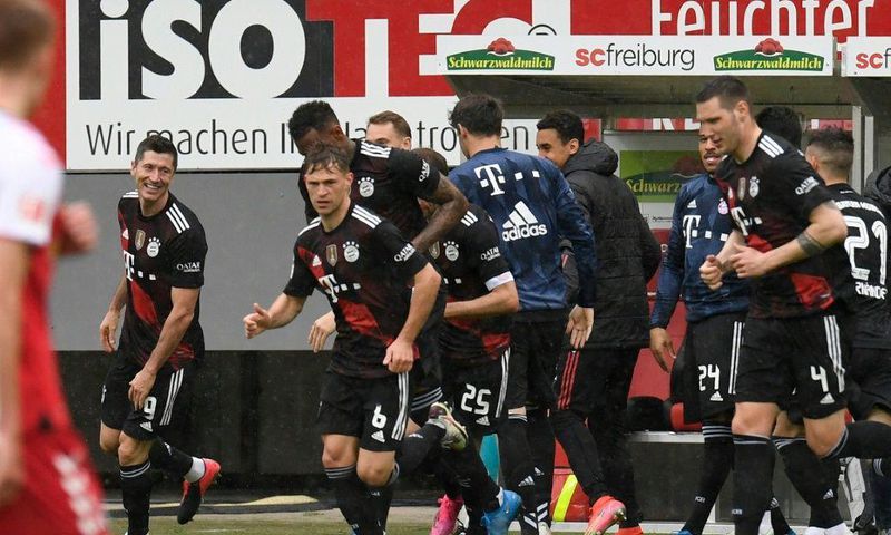 Bayern Munich striker Robert Lewandowski (L) celebrates scoring his 40th Bundesliga goal this season to equal Gerd Mueller's 49-year-old record