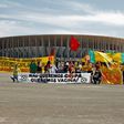 Demonstrators stand behind a banner reading 'We don't want the Copa, we want  vaccines' outside the Mane Garrincha stadium before the Copa America opening game