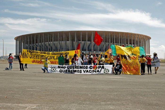 Demonstrators stand behind a banner reading 'We don't want the Copa, we want  vaccines' outside the Mane Garrincha stadium before the Copa America opening game