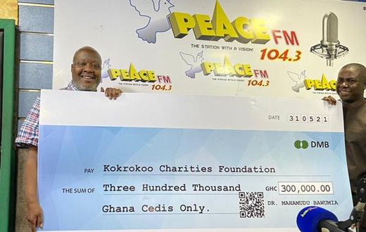 Kwami Sefa Kayi holding the cheque