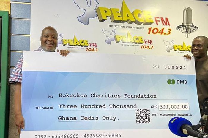 Kwami Sefa Kayi holding the cheque