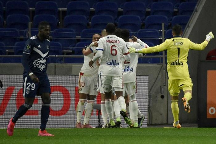 Lyon players surrounded Leo Dubois after his later winner against Bordeaux