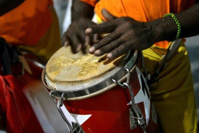 The dancing is accompanied by the five-step clave beat from African drums