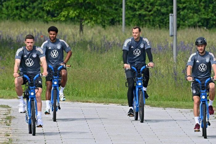 Serge Gnabry (second from left) cycles to Germany's training session on Friday with his team-mates