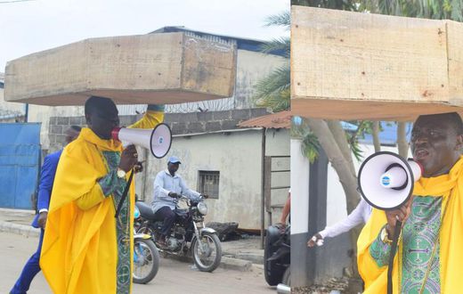 Archbishop Samson Benjamin embarks on a one-man protest with a coffin on his head