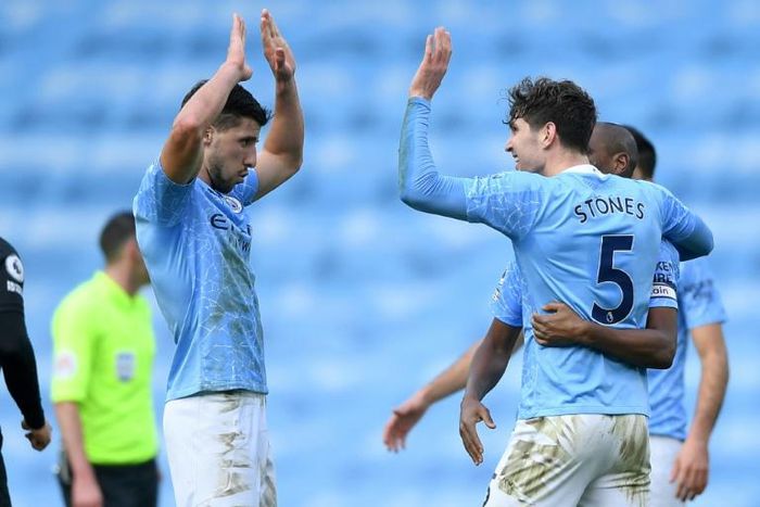 Ruben Dias (left) and John Stones struck to send Manchester City 13 points clear in the Premier League