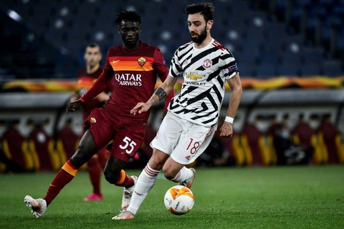 Roma's Gambian defender Ebrima Darboe (L) fights for the ball with Manchester United's Bruno Fernandes.