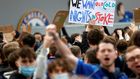 Football supporters hold placards as they demonstrate against the proposed European Super League