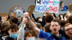 Football supporters hold placards as they demonstrate against the proposed European Super League