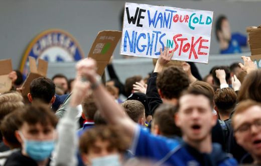 Football supporters hold placards as they demonstrate against the proposed European Super League