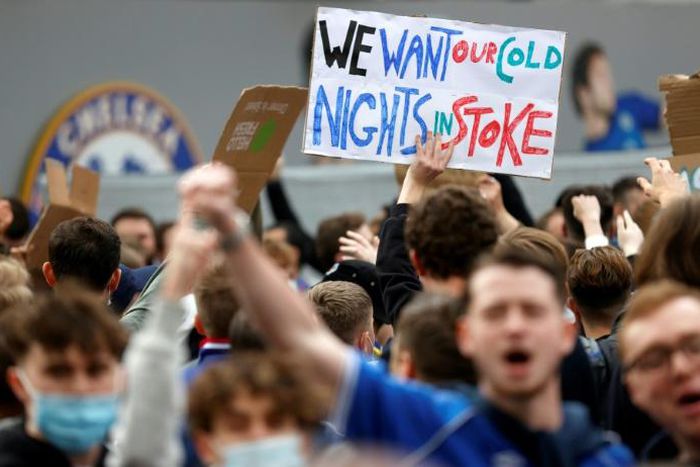 Football supporters hold placards as they demonstrate against the proposed European Super League