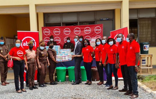 Absa Bank employees presenting the items to officials of the Senior Correctional Centre