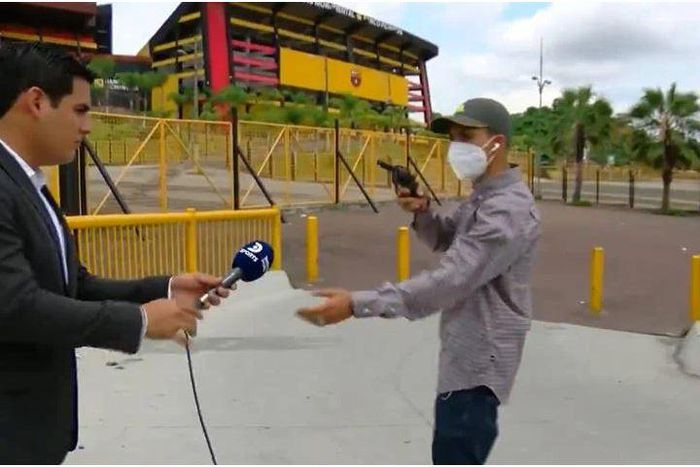 Mask-wearing robber robs journalist at gunpoint during live report