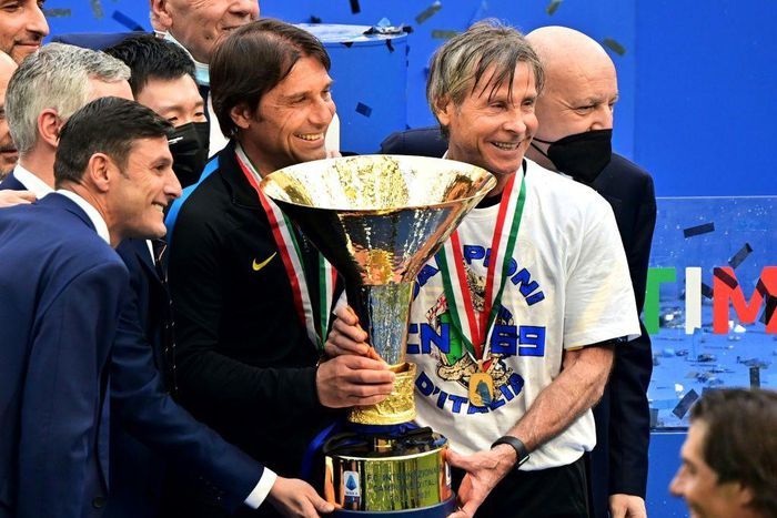 Inter Milan coach Antonio Conte (L) and team technical director Gabriele Oriali (R) hold the 'Scudetto' trophy.