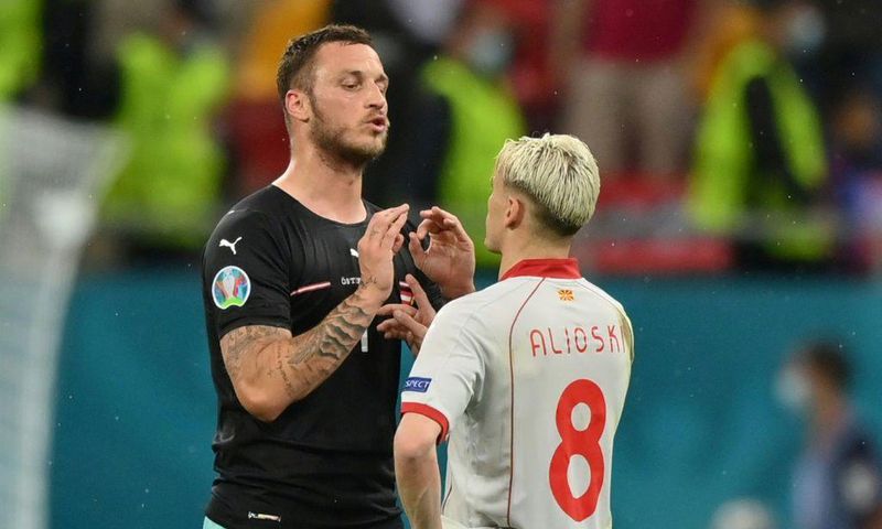 Austria's Marko Arnautovic (left) confronts North Macedonia defender Ezgjan Alioski in the Bucharest match on Sunday