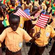 School children were on hand to welcome the American first lady, waving tiny Ghanaian and American flags.