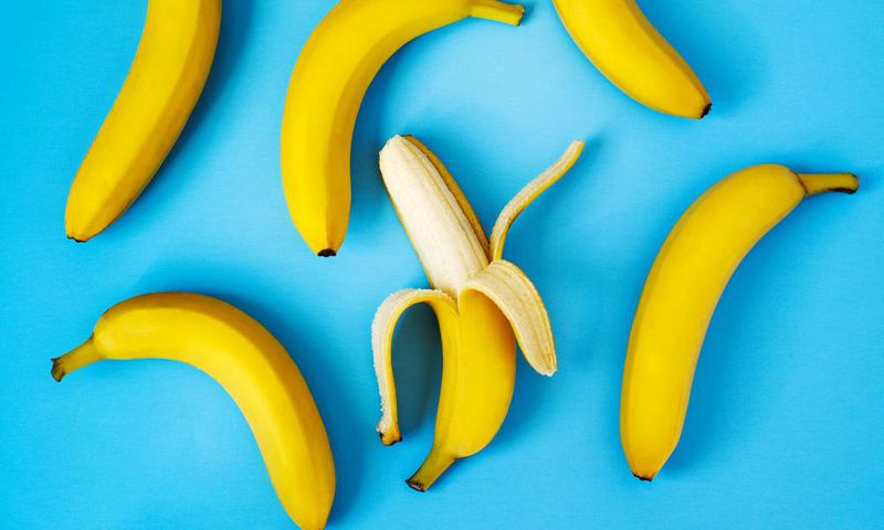 Ripe bananas on blue background