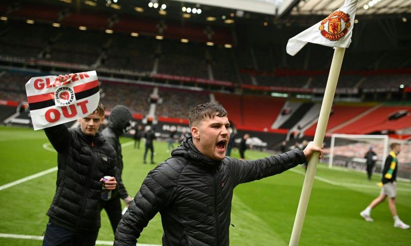 Fans protest against Manchester United's owners on the pitch at Old Trafford