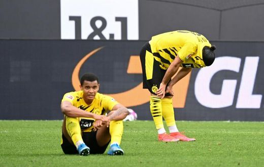 Dortmund defenders Manuel Akanji (L) and Emre Can (R) show their disappointment at Saturday's home defeat to Frankfurt which dents their Champions League hopes for next season