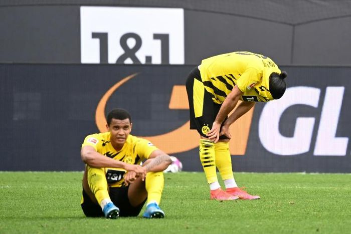 Dortmund defenders Manuel Akanji (L) and Emre Can (R) show their disappointment at Saturday's home defeat to Frankfurt which dents their Champions League hopes for next season