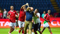 A Madagascar player pours water over coach Nicolas Dupuis (C) after  a shock victory over Nigeria at the 2019 Africa Cup of Nations in Egypt.