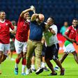 A Madagascar player pours water over coach Nicolas Dupuis (C) after  a shock victory over Nigeria at the 2019 Africa Cup of Nations in Egypt.