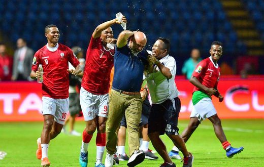 A Madagascar player pours water over coach Nicolas Dupuis (C) after  a shock victory over Nigeria at the 2019 Africa Cup of Nations in Egypt.