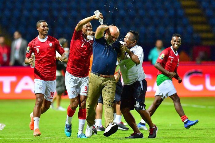 A Madagascar player pours water over coach Nicolas Dupuis (C) after  a shock victory over Nigeria at the 2019 Africa Cup of Nations in Egypt.