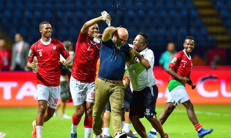 A Madagascar player pours water over coach Nicolas Dupuis (C) after  a shock victory over Nigeria at the 2019 Africa Cup of Nations in Egypt.