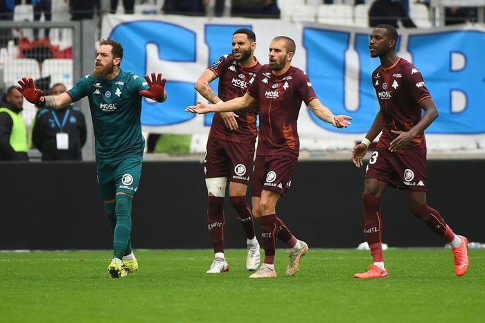 Unhappy: Metz players react after French referee Jerome Brisard gives a red card to Brazilian defender Jemerson