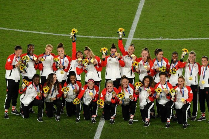 Canada pose with their Olympic gold medals after beating Sweden on penalties