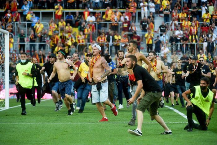 Lens supporters invade the pitch at half-time of the northern derby against Lille