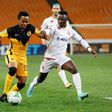 Simon Msuva (R) of Wydad Casablanca pursues  Nkosingiphile Ngcobo (L) of Kaizer Chiefs during a CAF Champions League semi-final second leg at Soccer City stadium in Johannesburg