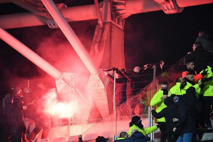 Flares blaze in the stands as the French cup match between Paris FC and Lyon is halted by fleeing fans